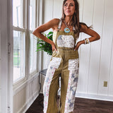 Light olive green washed cotton overalls with pastel floral patchwork throughout including on the adjustable traps with metal clasps and zippered sides.