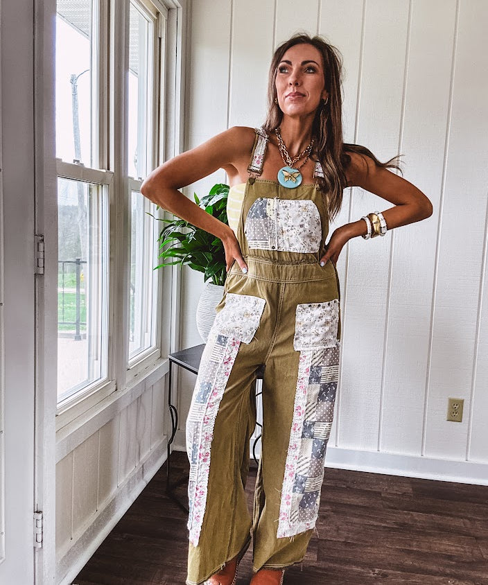 Light olive green washed cotton overalls with pastel floral patchwork throughout including on the adjustable traps with metal clasps and zippered sides.