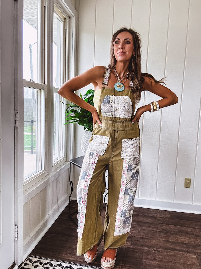 Light olive green washed cotton overalls with pastel floral patchwork throughout including on the adjustable traps with metal clasps and zippered sides.