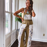 Light olive green washed cotton overalls with pastel floral patchwork throughout including on the adjustable traps with metal clasps and zippered sides.