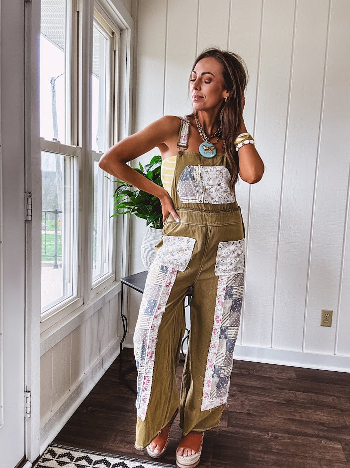 Light olive green washed cotton overalls with pastel floral patchwork throughout including on the adjustable traps with metal clasps and zippered sides.