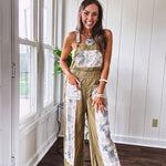 Light olive green washed cotton overalls with pastel floral patchwork throughout including on the adjustable traps with metal clasps and zippered sides.