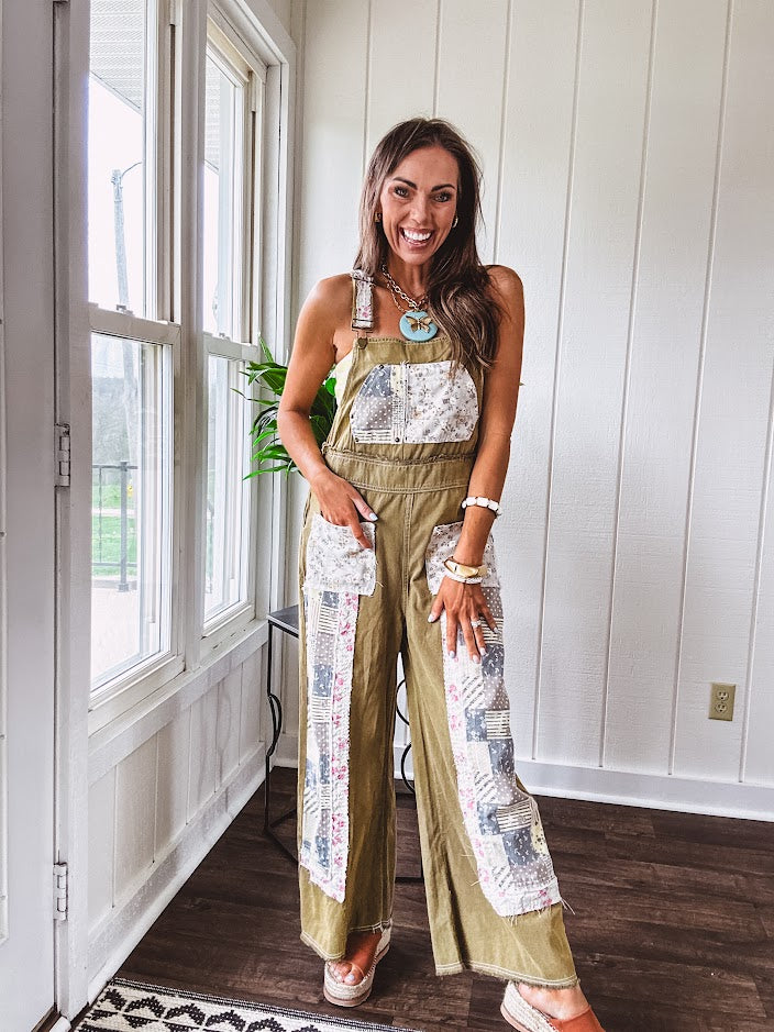 Light olive green washed cotton overalls with pastel floral patchwork throughout including on the adjustable traps with metal clasps and zippered sides.