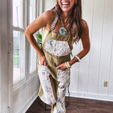 Light olive green washed cotton overalls with pastel floral patchwork throughout including on the adjustable traps with metal clasps and zippered sides.