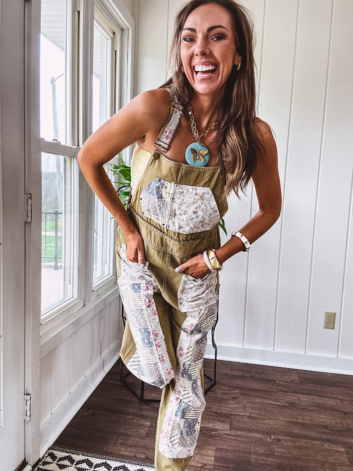 Light olive green washed cotton overalls with pastel floral patchwork throughout including on the adjustable traps with metal clasps and zippered sides.