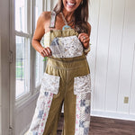 Light olive green washed cotton overalls with pastel floral patchwork throughout including on the adjustable traps with metal clasps and zippered sides.