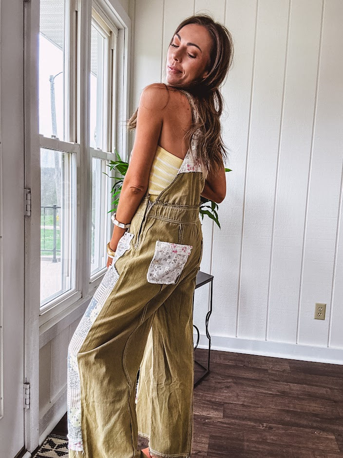 Light olive green washed cotton overalls with pastel floral patchwork throughout including on the adjustable traps with metal clasps and zippered sides.