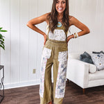 Light olive green washed cotton overalls with pastel floral patchwork throughout including on the adjustable traps with metal clasps and zippered sides.