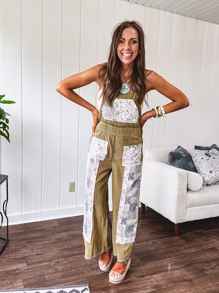 Light olive green washed cotton overalls with pastel floral patchwork throughout including on the adjustable traps with metal clasps and zippered sides.