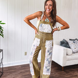 Light olive green washed cotton overalls with pastel floral patchwork throughout including on the adjustable traps with metal clasps and zippered sides.