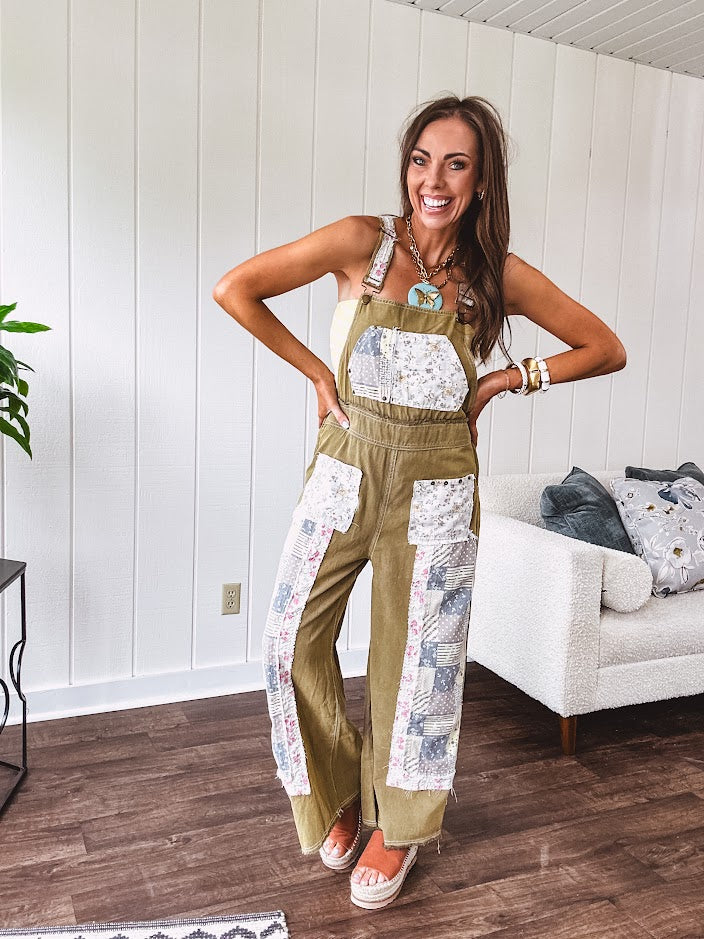 Light olive green washed cotton overalls with pastel floral patchwork throughout including on the adjustable traps with metal clasps and zippered sides.