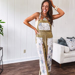 Light olive green washed cotton overalls with pastel floral patchwork throughout including on the adjustable traps with metal clasps and zippered sides.