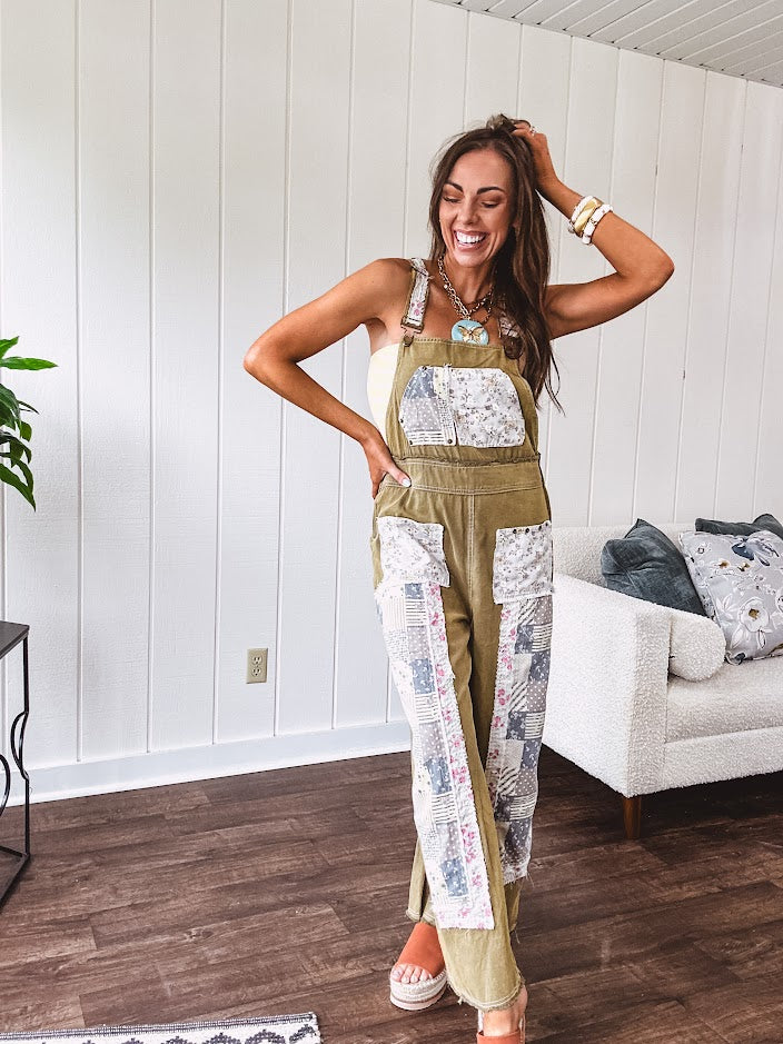 Light olive green washed cotton overalls with pastel floral patchwork throughout including on the adjustable traps with metal clasps and zippered sides.