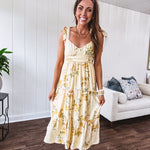 Flowy and soft butter yellow and floral midi dress with eyelet detail on the tie straps, detailed bodice with smocking at the back and a tiered skirt, fully lined.