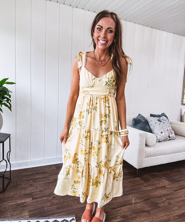 Flowy and soft butter yellow and floral midi dress with eyelet detail on the tie straps, detailed bodice with smocking at the back and a tiered skirt, fully lined.