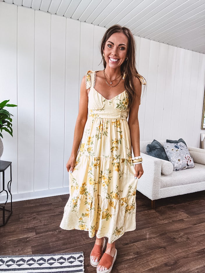 Flowy and soft butter yellow and floral midi dress with eyelet detail on the tie straps, detailed bodice with smocking at the back and a tiered skirt, fully lined.