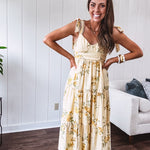 Flowy and soft butter yellow and floral midi dress with eyelet detail on the tie straps, detailed bodice with smocking at the back and a tiered skirt, fully lined.