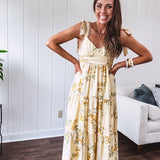 Flowy and soft butter yellow and floral midi dress with eyelet detail on the tie straps, detailed bodice with smocking at the back and a tiered skirt, fully lined.