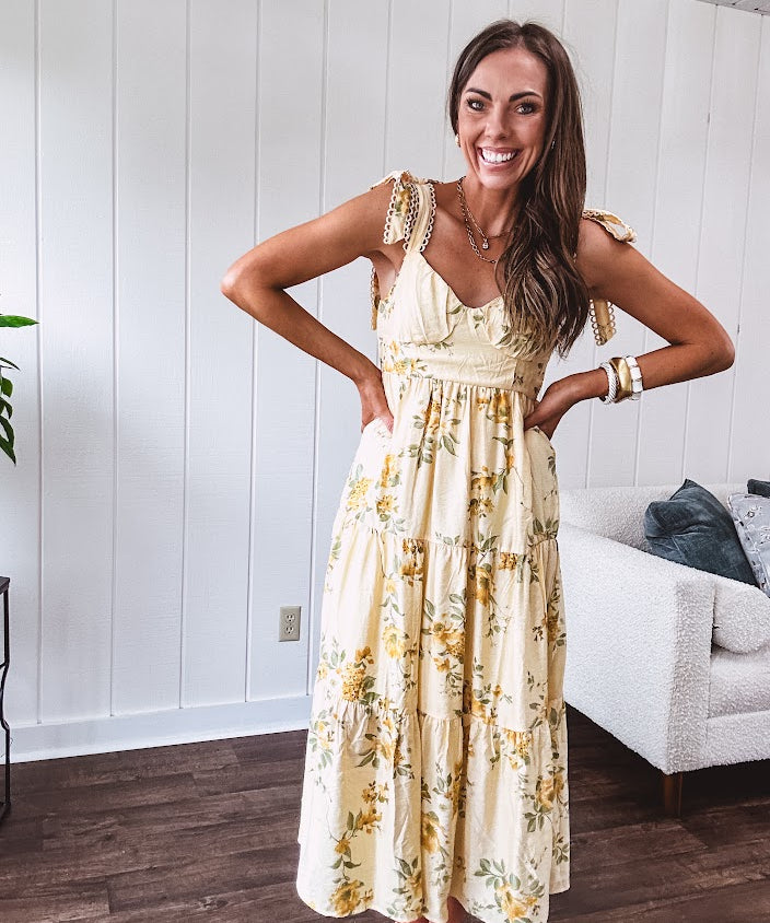 Flowy and soft butter yellow and floral midi dress with eyelet detail on the tie straps, detailed bodice with smocking at the back and a tiered skirt, fully lined.