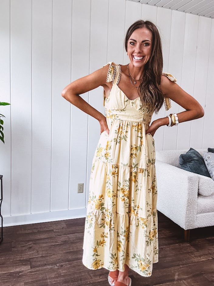 Flowy and soft butter yellow and floral midi dress with eyelet detail on the tie straps, detailed bodice with smocking at the back and a tiered skirt, fully lined.