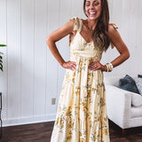 Flowy and soft butter yellow and floral midi dress with eyelet detail on the tie straps, detailed bodice with smocking at the back and a tiered skirt, fully lined.