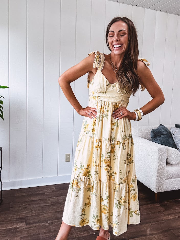 Flowy and soft butter yellow and floral midi dress with eyelet detail on the tie straps, detailed bodice with smocking at the back and a tiered skirt, fully lined.