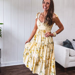 Flowy and soft butter yellow and floral midi dress with eyelet detail on the tie straps, detailed bodice with smocking at the back and a tiered skirt, fully lined.