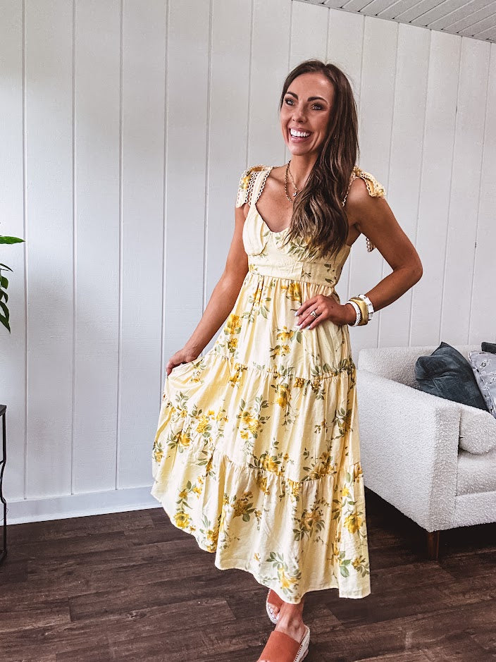 Flowy and soft butter yellow and floral midi dress with eyelet detail on the tie straps, detailed bodice with smocking at the back and a tiered skirt, fully lined.
