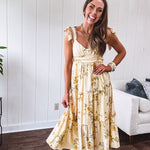 Flowy and soft butter yellow and floral midi dress with eyelet detail on the tie straps, detailed bodice with smocking at the back and a tiered skirt, fully lined.