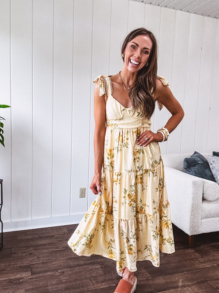 Flowy and soft butter yellow and floral midi dress with eyelet detail on the tie straps, detailed bodice with smocking at the back and a tiered skirt, fully lined.