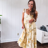 Flowy and soft butter yellow and floral midi dress with eyelet detail on the tie straps, detailed bodice with smocking at the back and a tiered skirt, fully lined.