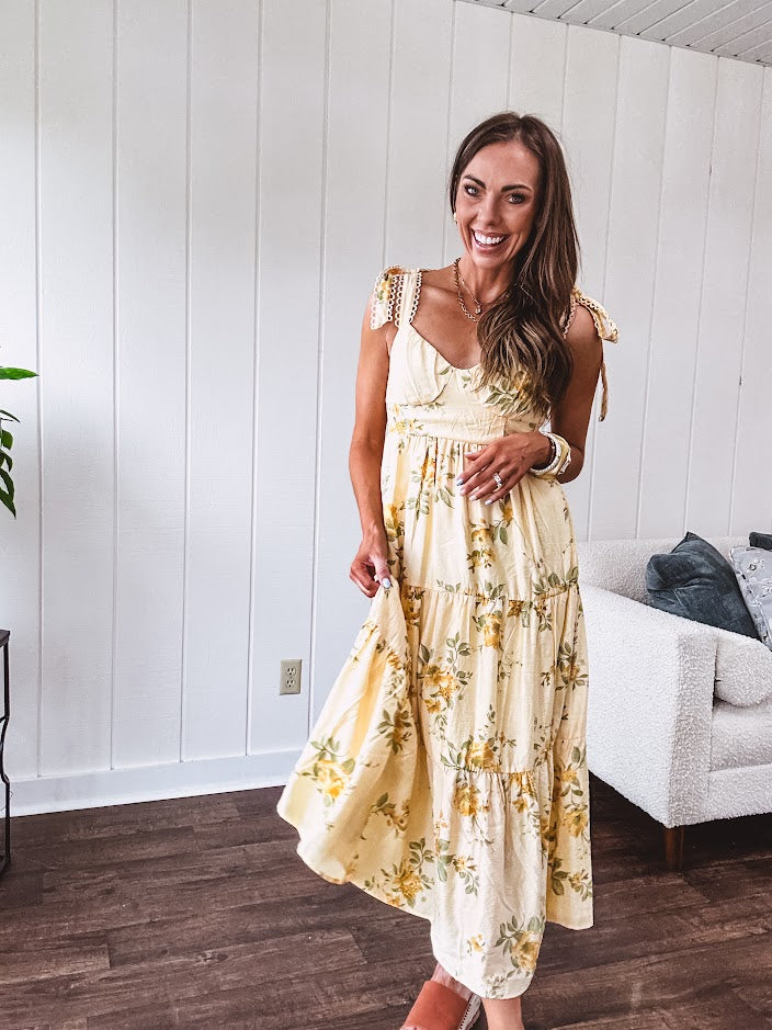 Flowy and soft butter yellow and floral midi dress with eyelet detail on the tie straps, detailed bodice with smocking at the back and a tiered skirt, fully lined.