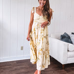 Flowy and soft butter yellow and floral midi dress with eyelet detail on the tie straps, detailed bodice with smocking at the back and a tiered skirt, fully lined.