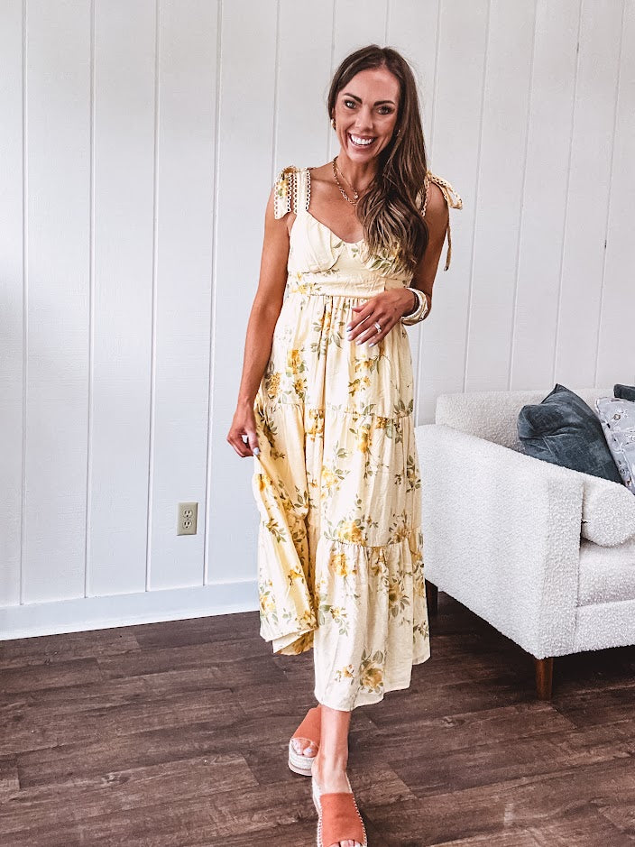 Flowy and soft butter yellow and floral midi dress with eyelet detail on the tie straps, detailed bodice with smocking at the back and a tiered skirt, fully lined.