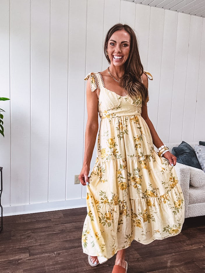 Flowy and soft butter yellow and floral midi dress with eyelet detail on the tie straps, detailed bodice with smocking at the back and a tiered skirt, fully lined.
