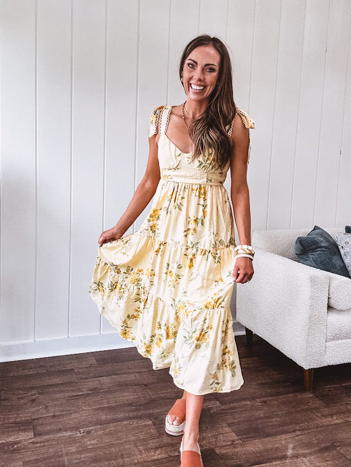 Flowy and soft butter yellow and floral midi dress with eyelet detail on the tie straps, detailed bodice with smocking at the back and a tiered skirt, fully lined.