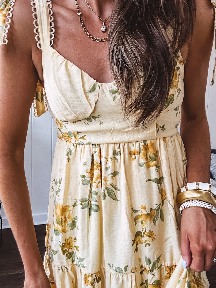 Flowy and soft butter yellow and floral midi dress with eyelet detail on the tie straps, detailed bodice with smocking at the back and a tiered skirt, fully lined.