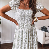 White dress with green dainty vines print, capped elastic sleeves and elastic square neckline, smocked bodice and tiered, fully lined skirt.