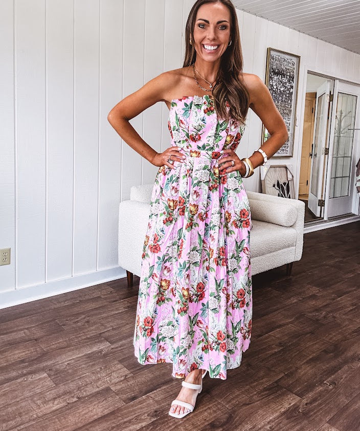Pink strapless midi dress with floral and berry motif in red, blue and white with pleated front bodice and back smocked bodice, fully lined pleated skirt, with pockets.