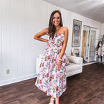Pink strapless midi dress with floral and berry motif in red, blue and white with pleated front bodice and back smocked bodice, fully lined pleated skirt, with pockets.