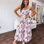 Pink strapless midi dress with floral and berry motif in red, blue and white with pleated front bodice and back smocked bodice, fully lined pleated skirt, with pockets.