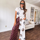 Soft cap sleeved mock neck cream top with a shorter waist and black and leo 8 ball motif throughout.