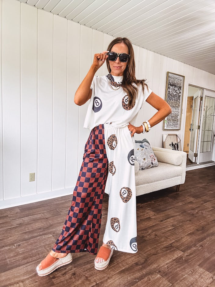 Soft cap sleeved mock neck cream top with a shorter waist and black and leo 8 ball motif throughout.