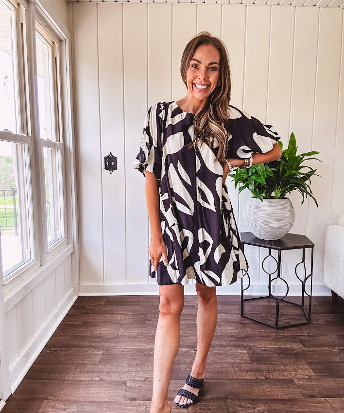 Short black and ivory abstract print dress, fully lined with hook and eye neck closure and puffed sleeves.