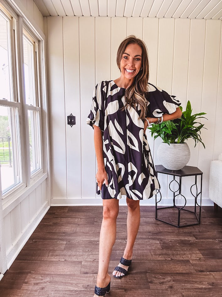 Short black and ivory abstract print dress, fully lined with hook and eye neck closure and puffed sleeves.