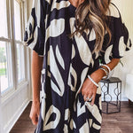Short black and ivory abstract print dress, fully lined with hook and eye neck closure and puffed sleeves.