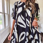 Short black and ivory abstract print dress, fully lined with hook and eye neck closure and puffed sleeves.