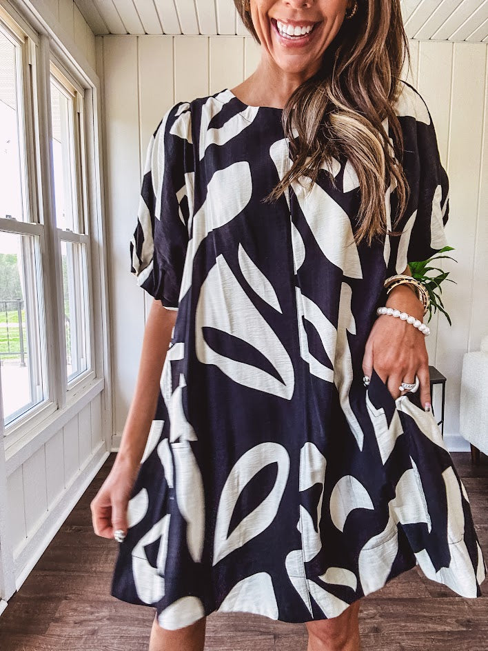 Short black and ivory abstract print dress, fully lined with hook and eye neck closure and puffed sleeves.