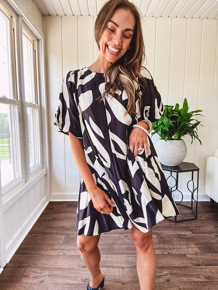Short black and ivory abstract print dress, fully lined with hook and eye neck closure and puffed sleeves.