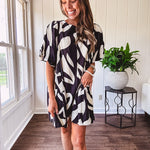 Short black and ivory abstract print dress, fully lined with hook and eye neck closure and puffed sleeves.